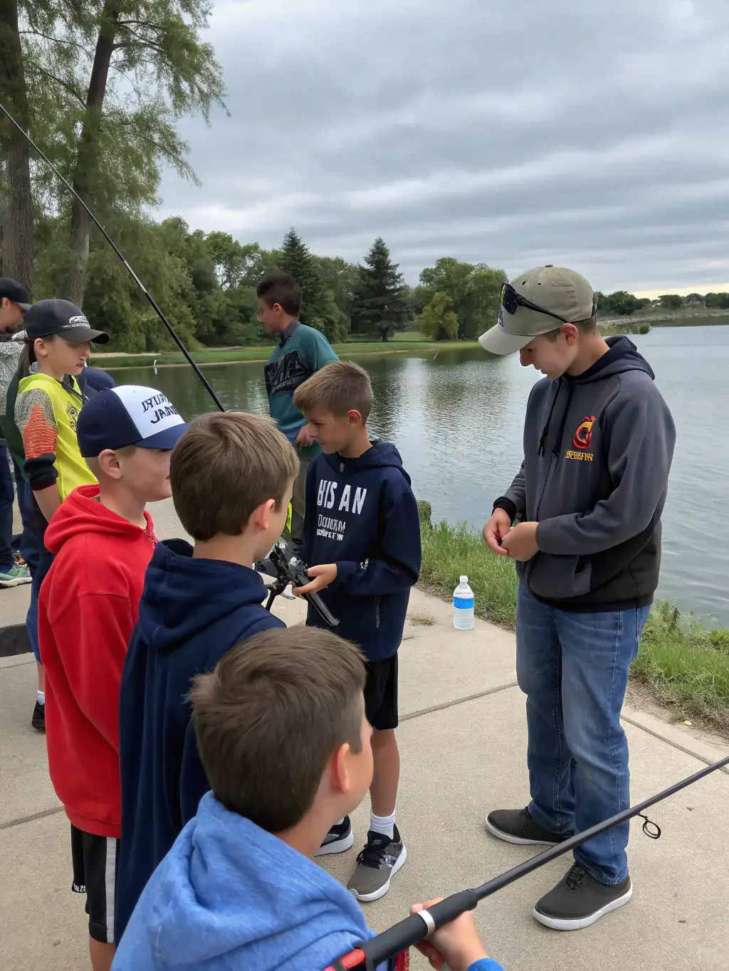 A group of children participating in a fly fishing workshop, smiling and engaged, with a clear river in the background, demonstrating community engagement and skill development.